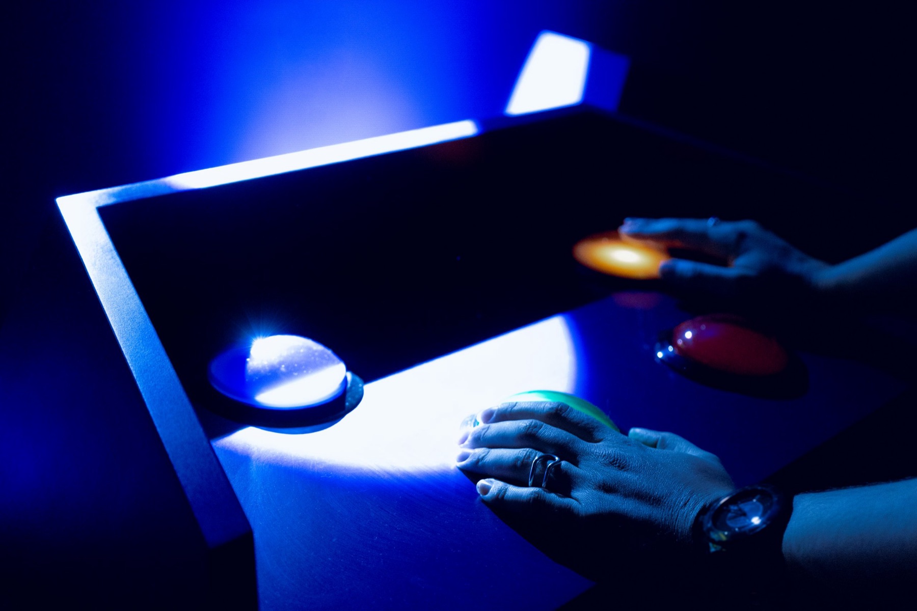 Mains de joueurs sur les buzzers lumineux du Quiz Game