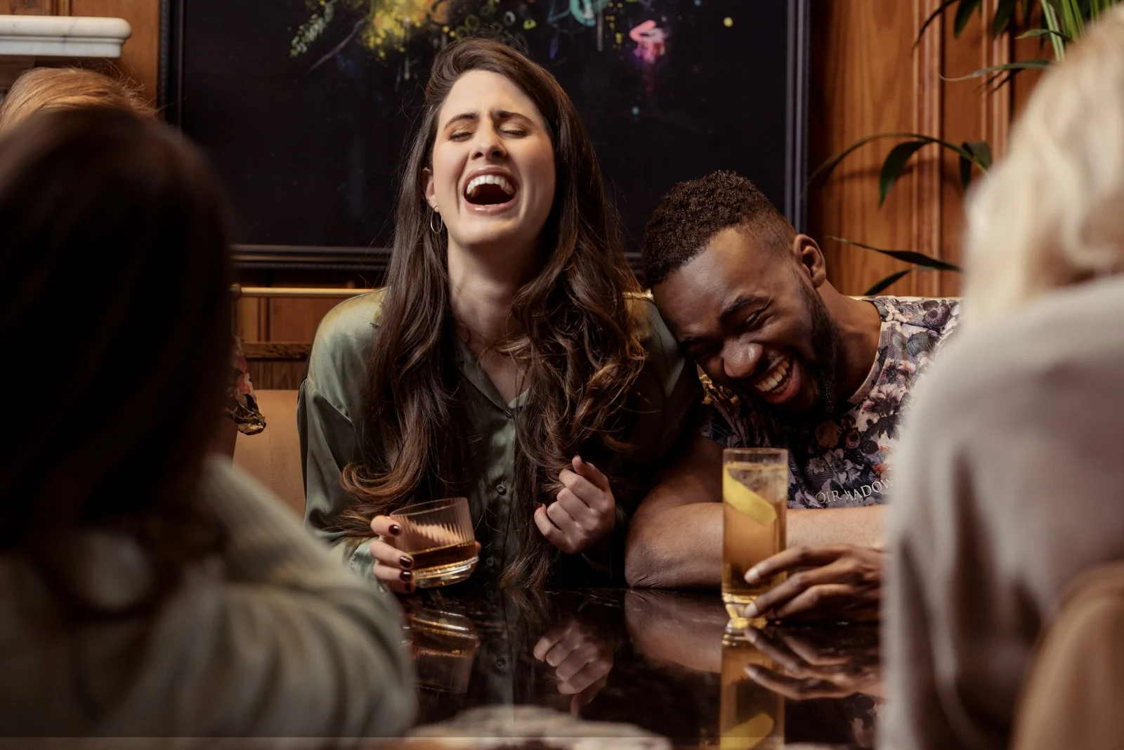 Deux amis éclatent de rire autour d’une table
